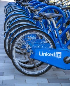 שורה של אופניים רגילים להשכרה חונים אחד ליד השני בצבע כחול והלוגו של לינקדאין